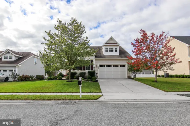 a view of a house with a big yard plants and large trees