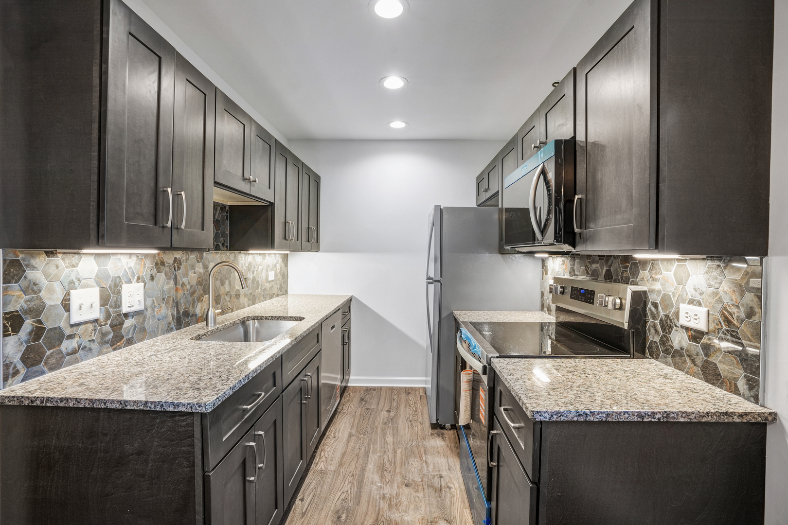 535 Pasadena Avenue, Unit 3 Crest Hill, IL 60403 - Photo 3 of 10 a kitchen with stainless steel appliances granite countertop a sink a stove and a wooden floors