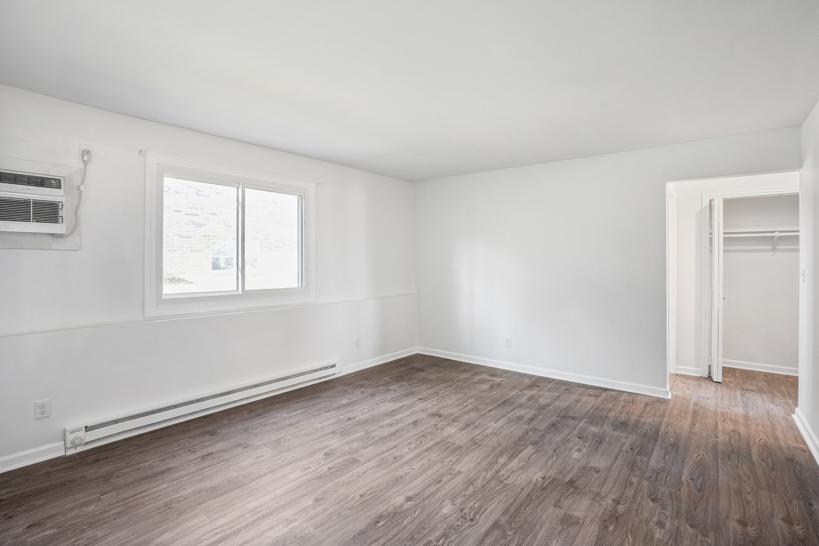 535 Pasadena Avenue, Unit 3 Crest Hill, IL 60403 - Photo 5 of 10 an empty room with wooden floor and windows