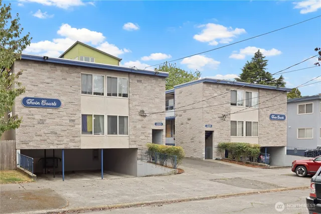 a view of a white house with large windows and a table and chairs