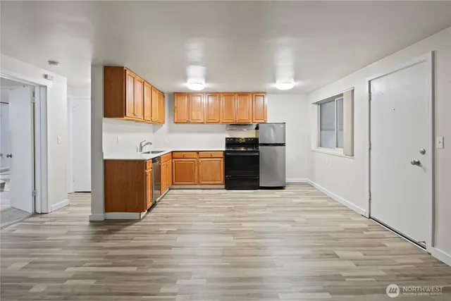 a large kitchen with stainless steel appliances granite countertop a refrigerator and a stove top oven