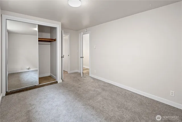 a view of a hallway with wooden floor and closet