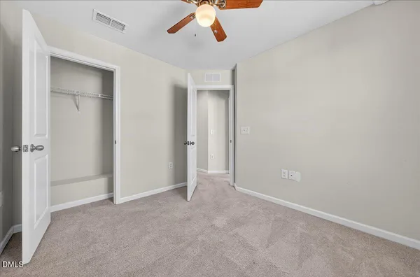 a view of an empty room with a ceiling fan
