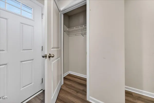 a view of a hallway with wooden floor and closet