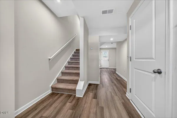 a view of a hallway with wooden floor and entryway