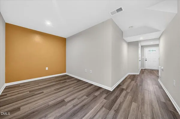 a view of an empty room with wooden floor