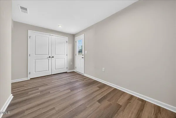 a view of an empty room with wooden floor