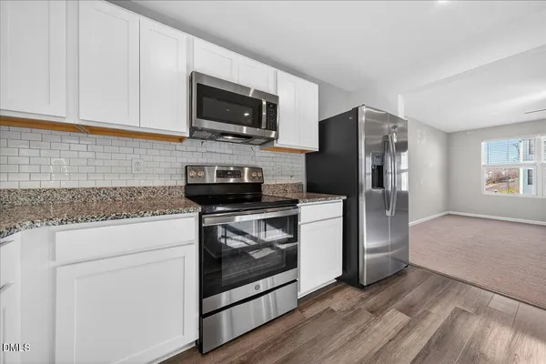 a kitchen with stainless steel appliances granite countertop a stove a refrigerator and a microwave