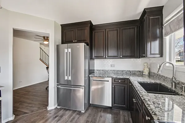 a kitchen with stainless steel appliances granite countertop a refrigerator stove and sink