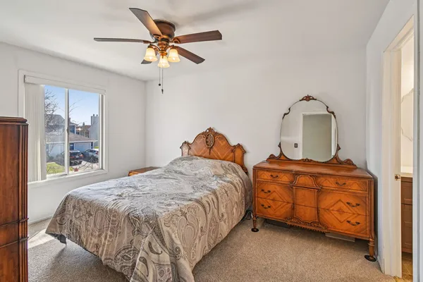 a bedroom with a bed dresser and a window