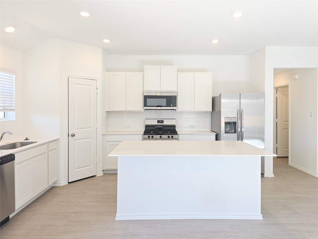 1117 Nesting Bird Drive Georgetown, TX 78628 - Photo 5 of 20 a large white kitchen with cabinets and stainless steel appliances