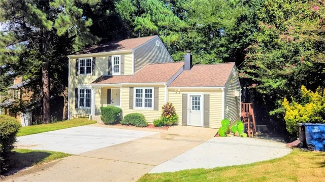 a front view of a house with a garden and plants