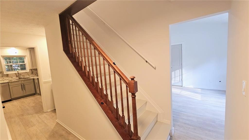 10505 Ash Rill Drive Alpharetta, GA 30022 - Photo 20 of 57 a view of a hallway with wooden floor and staircase