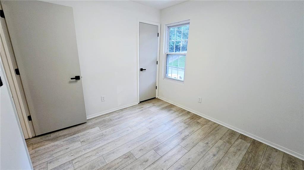 10505 Ash Rill Drive Alpharetta, GA 30022 - Photo 34 of 57 an empty room with wooden floor and windows