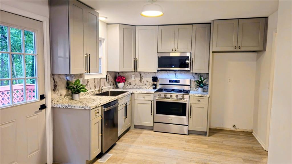 10505 Ash Rill Drive Alpharetta, GA 30022 - Photo 50 of 57 a kitchen with stainless steel appliances granite countertop a stove a sink and a refrigerator