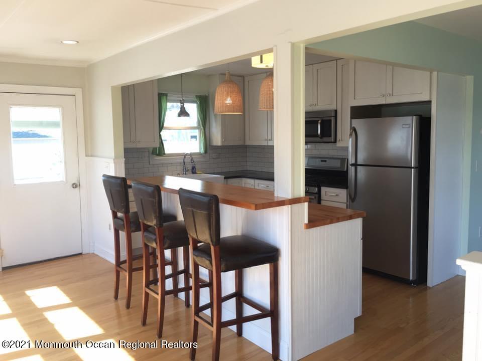 124 Gary Road Toms River, NJ 08753 - Photo 7 of 18 a kitchen with stainless steel appliances granite countertop a dining table chairs refrigerator and sink