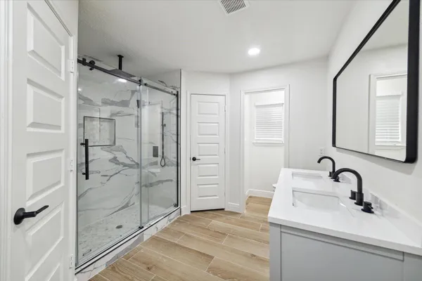 a bathroom with a shower sink and mirror
