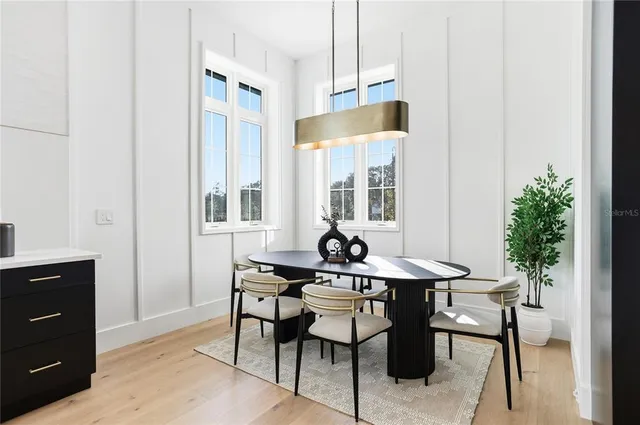 a dining room with furniture potted plants and wooden floor