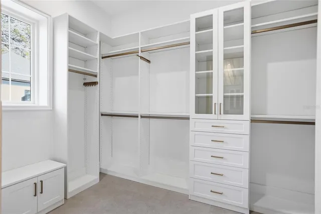 a bedroom with a large bed and a potted plant