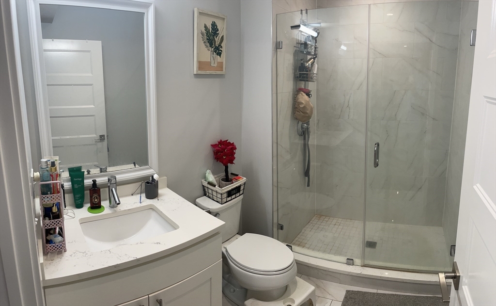 151 Hancock Street, Unit 5 Quincy, MA 02171 - Photo 6 of 12 a bathroom with a sink toilet and shower