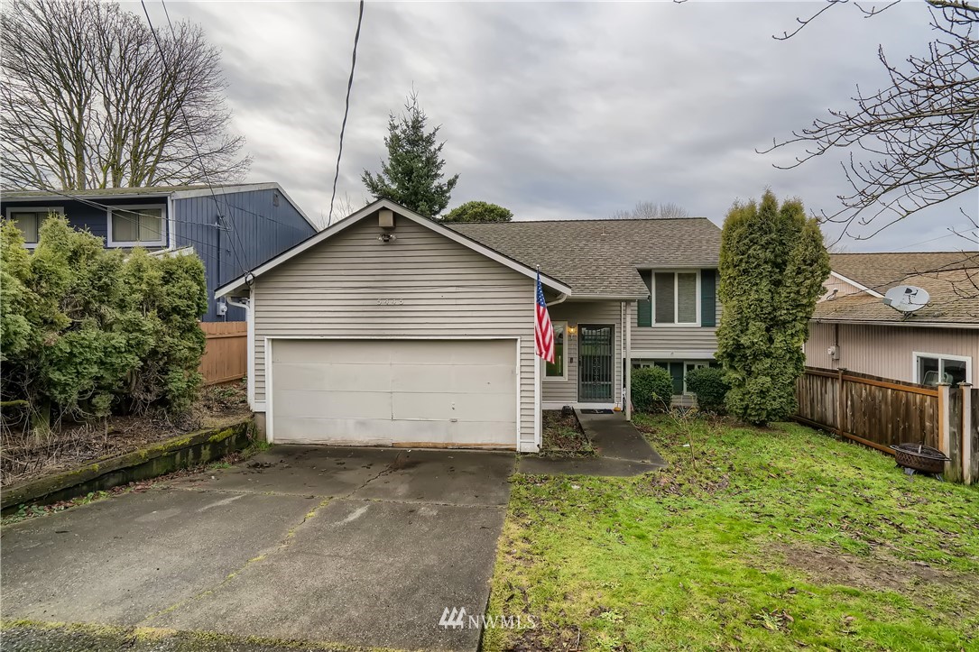 a front view of house with yard and garage