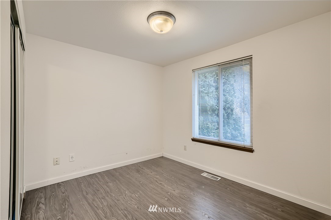 5445 17th Avenue Southwest Seattle, WA 98106 - Photo 14 of 19 a view of an empty room with a window and wooden floor