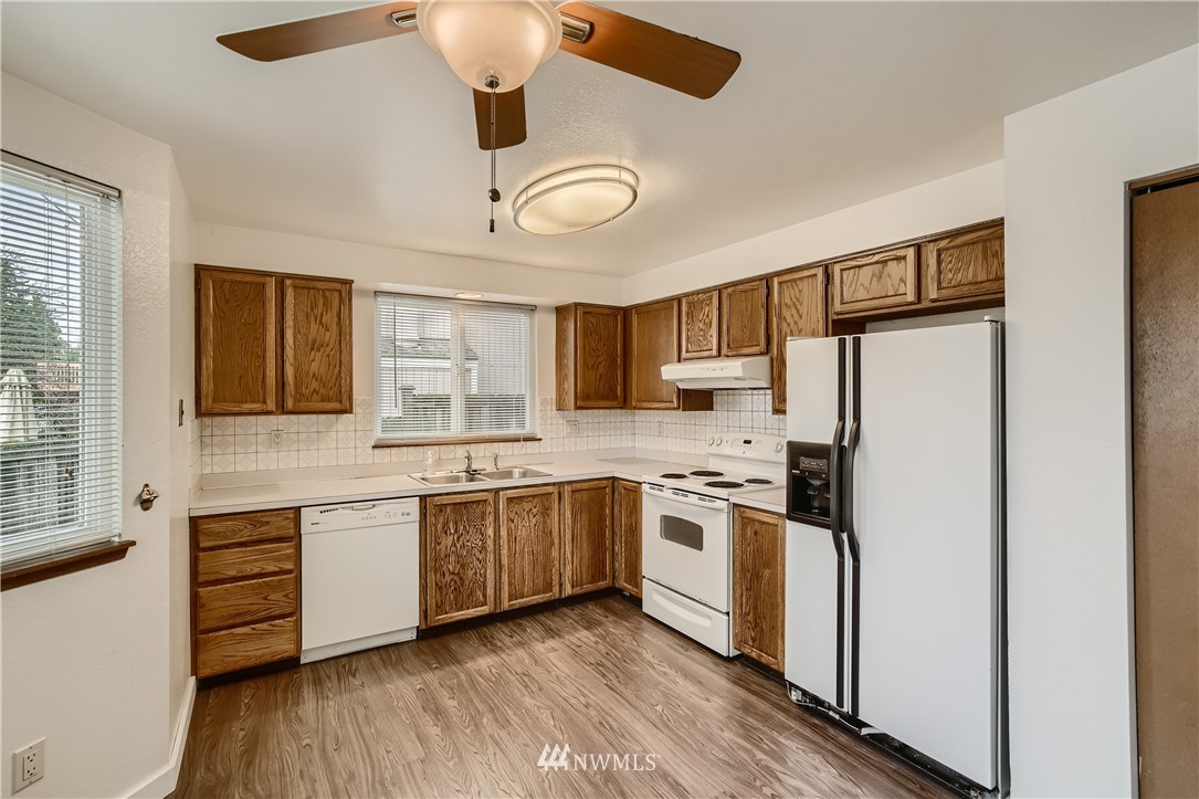 5445 17th Avenue Southwest Seattle, WA 98106 - Photo 5 of 19 a large kitchen with stainless steel appliances granite countertop a stove and a refrigerator
