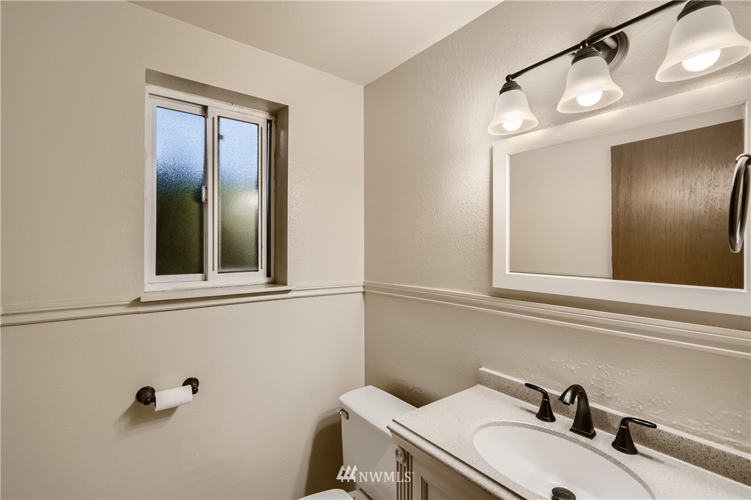 5445 17th Avenue Southwest Seattle, WA 98106 - Photo 7 of 19 a bathroom with a sink and a mirror