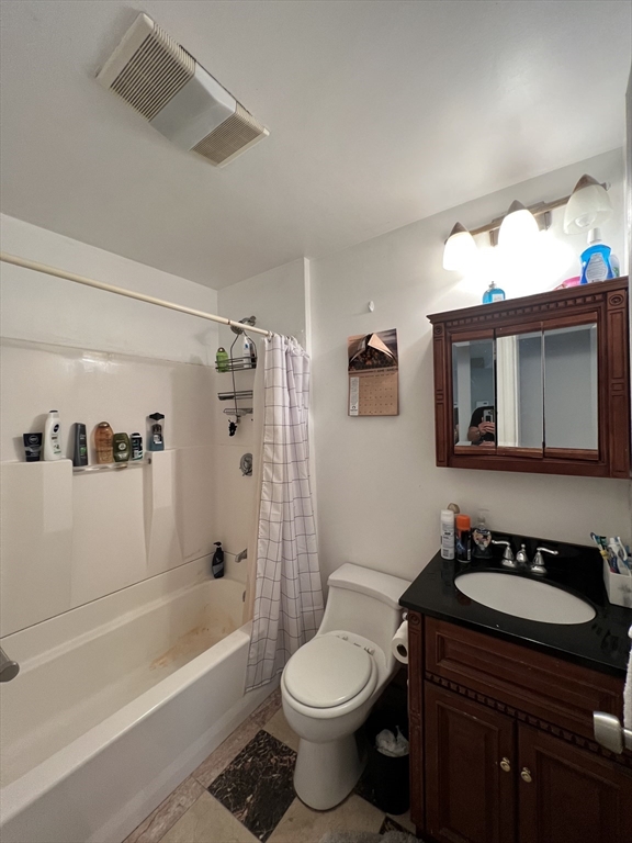 89 Spring Street, Unit 3 Cambridge, MA 02141 - Photo 5 of 9 a bathroom with a sink a toilet a mirror a vanity and bathtub