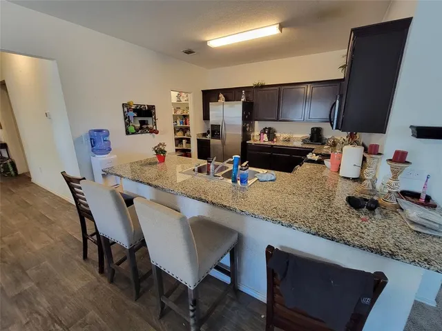 a kitchen with granite countertop kitchen island stainless steel appliances a sink a stove a table and chairs