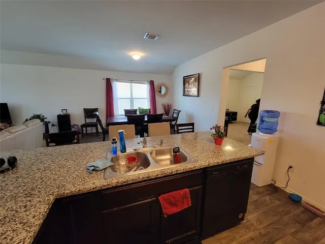 a room with granite countertop sink and natural light