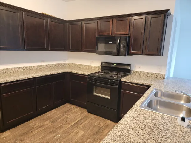 a kitchen with wooden cabinets and a stove top oven