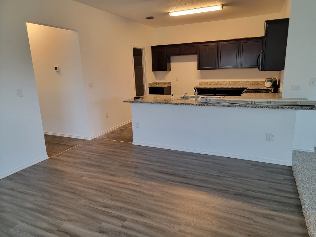 3610 Batson Drive Austin, TX 78725 - Photo 15 of 30 a view of kitchen with wooden floor and cabinets