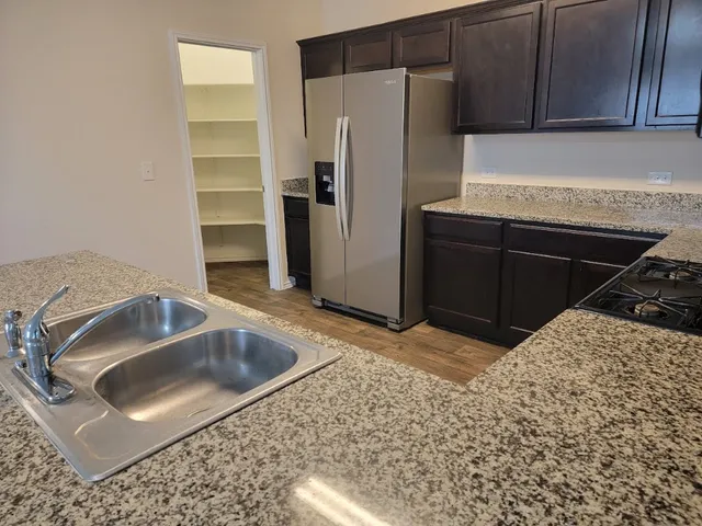 a kitchen with a refrigerator sink and cabinets