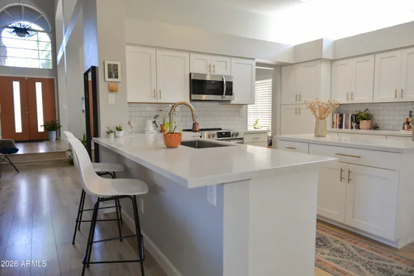 a kitchen with a sink cabinets and wooden floor