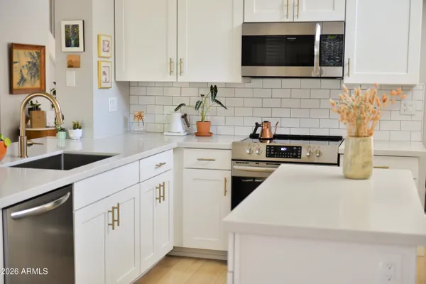 a kitchen with stainless steel appliances white cabinets and sink
