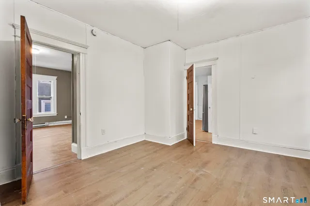 an empty room with wooden floor and closet