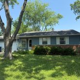 a front view of a house with a yard and potted plants