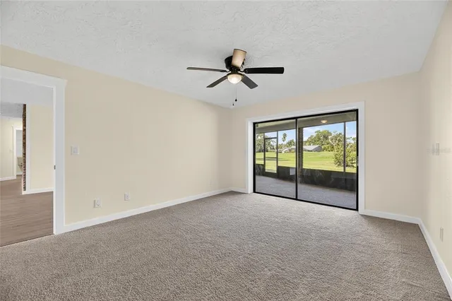 an empty room with windows and fan