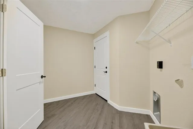 a view of empty room with wooden floor and fireplace