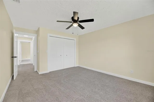 a view of an empty room with wooden floor fireplace and a window