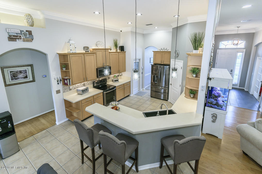 12171 Captiva Bluff Road Jacksonville, FL 32226 - Photo 36 of 36 a kitchen with a table chairs refrigerator and microwave