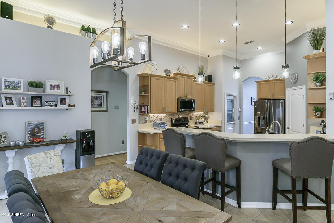 12171 Captiva Bluff Road Jacksonville, FL 32226 - Photo 15 of 36 a kitchen with stainless steel appliances kitchen island granite countertop a table and chairs in it