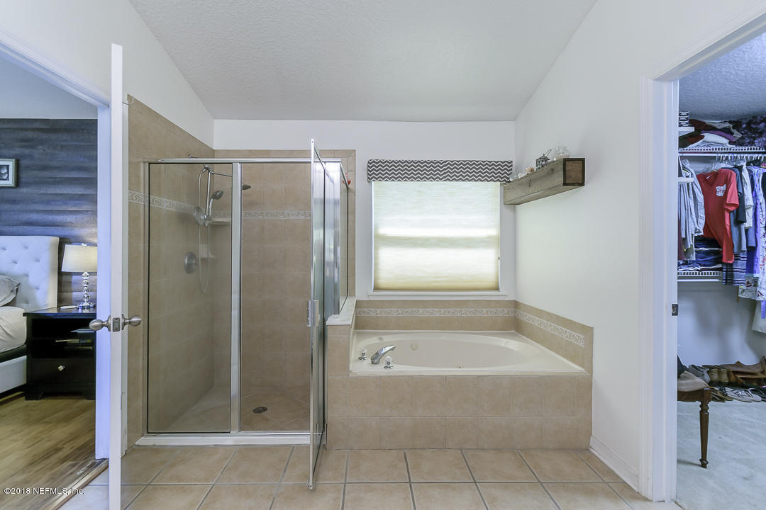 12171 Captiva Bluff Road Jacksonville, FL 32226 - Photo 19 of 36 a bathroom with a tub and shower
