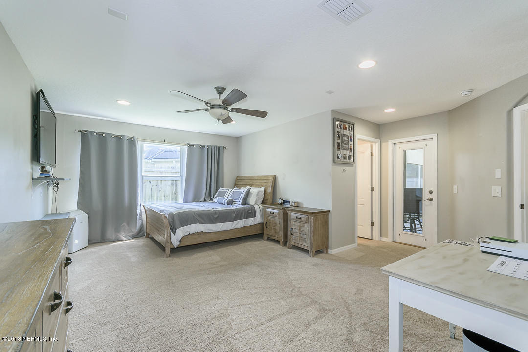12171 Captiva Bluff Road Jacksonville, FL 32226 - Photo 20 of 36 a spacious bedroom with a bed and a table chair