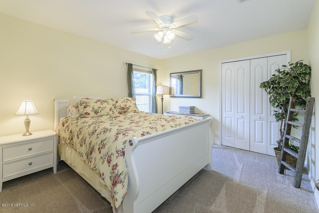 12171 Captiva Bluff Road Jacksonville, FL 32226 - Photo 22 of 36 a spacious bedroom with a bed and a potted plant