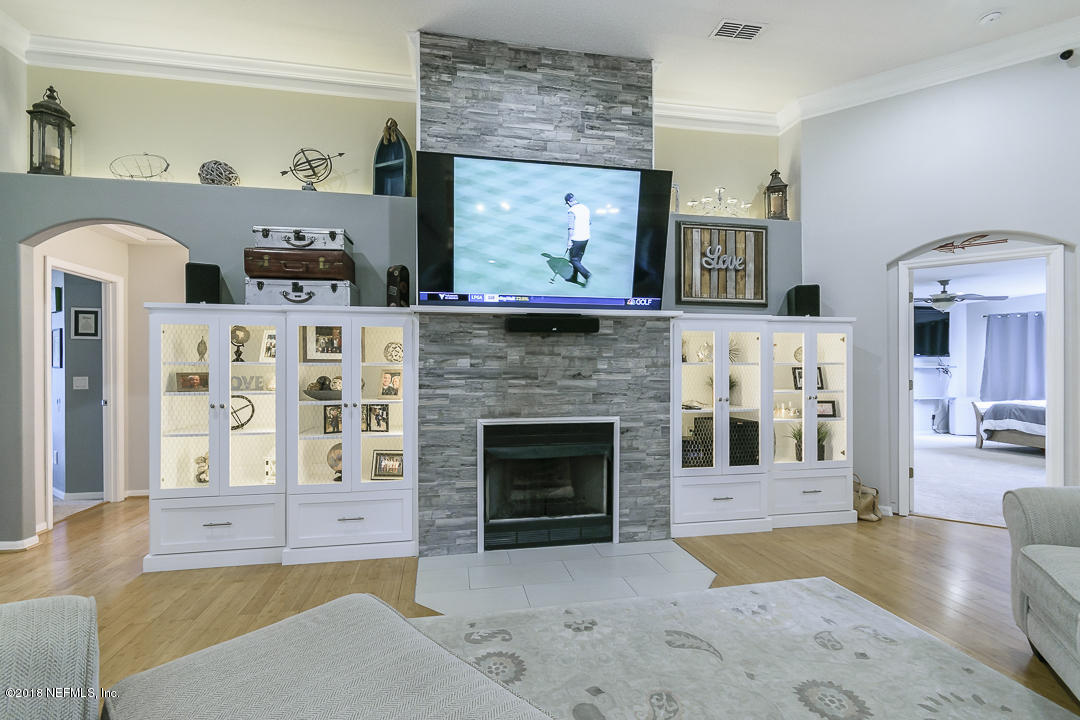 12171 Captiva Bluff Road Jacksonville, FL 32226 - Photo 10 of 36 a living room with furniture a fireplace and a flat screen tv