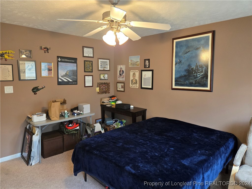 6723 Camden Road Fayetteville, NC 28306 - Photo 13 of 18 a bed room with a bed and a chandelier