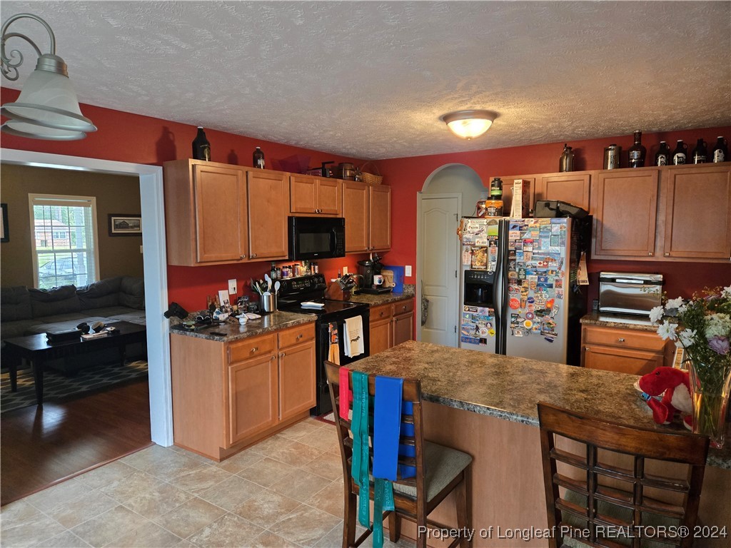 6723 Camden Road Fayetteville, NC 28306 - Photo 6 of 18 a kitchen with refrigerator and chairs