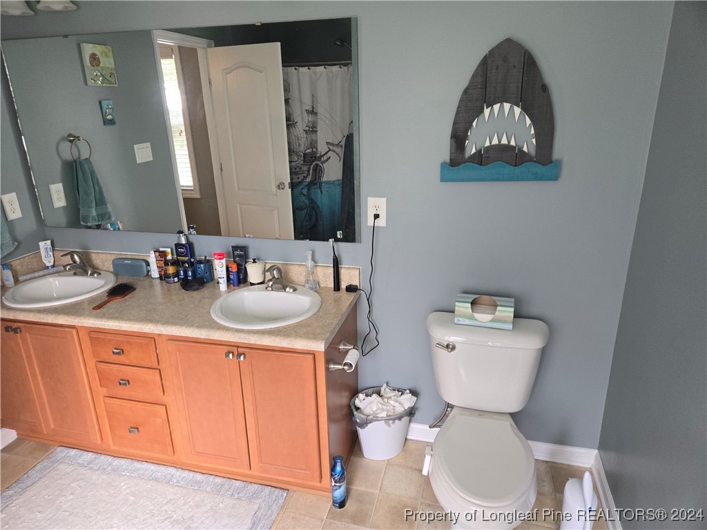6723 Camden Road Fayetteville, NC 28306 - Photo 10 of 18 a bathroom with a toilet sink and mirror